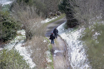 Archivo - Dos peregrinos caminan entre la nieve en Liñares, Lugo, Galicia (España).