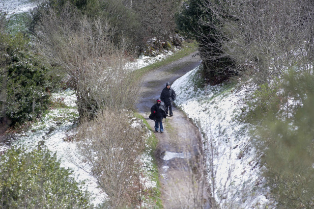 Archivo - Dos peregrinos caminan entre la nieve en Liñares, Lugo, Galicia (España).