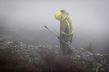 Un bombero trabaja en las labores de extinción de un incendio forestal en Ourol