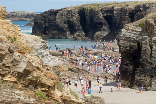 Archivo - Turistas pasean por la playa de As Catedrais.