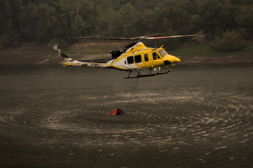 Archivo - Un helicóptero recoge agua para ayudar con las labores de extinción del incendio, a 26 de agosto de 2025, en Aguas Mestas, Lugo, Galicia (España). Las condiciones parecen mejorar en la pr