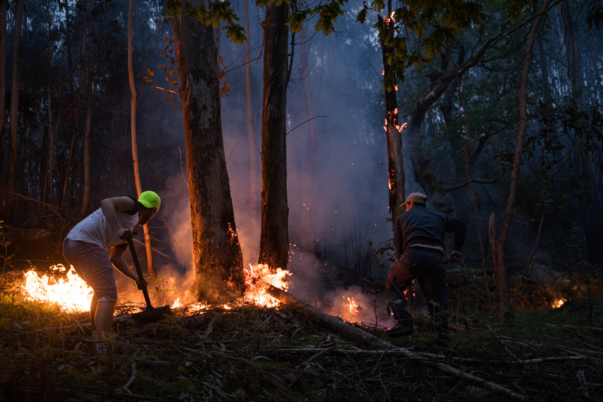 Varias personas intentan sofocar el fuego en el incendio forestal en el monte Galleiro, a 6 de abril de 2026, en Ribadetea, Ponteareas, Pontevedra, Galicia.