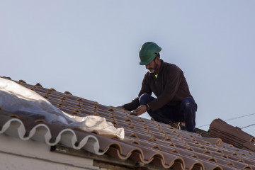 Archivo - Un obrero realiza su labor en el tejado de una vivienda, en foto de archivo.
