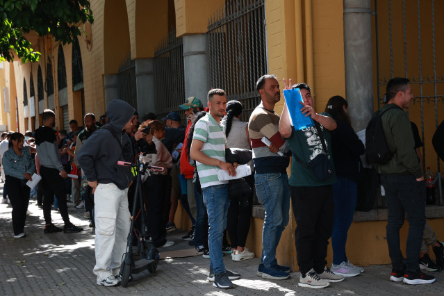 Personas migrantes hacen cola para la tramitación de su regularización administrativa en Sevilla. A 20 de abril de 2026 en Sevilla (Andalucía, España). Oficinas de Correos, de la Seguridad Social y de Extranjería comienzan este lunes 20 de abril a atender