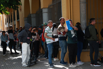 Personas migrantes hacen cola para la tramitación de su regularización administrativa en Sevilla.