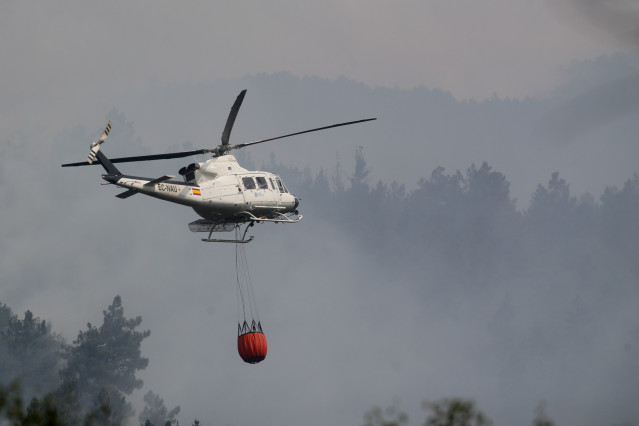 Archivo - Un helicóptero trabaja en las labores de extinción de un incendio. Foto de archivo.